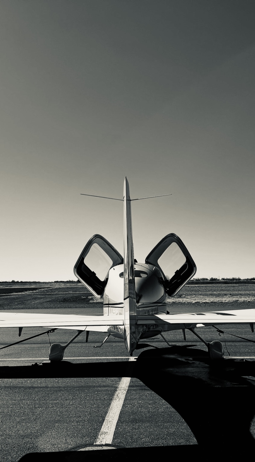 Cirrus aircraft with doors open on the runway